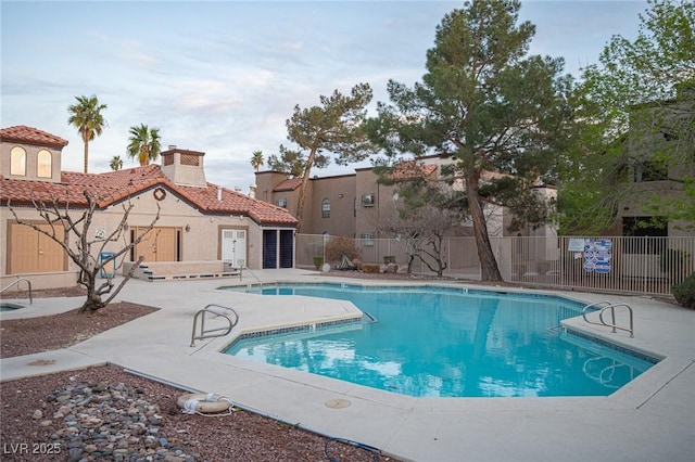 community pool featuring fence and a patio