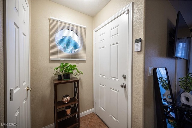 tiled foyer entrance with baseboards