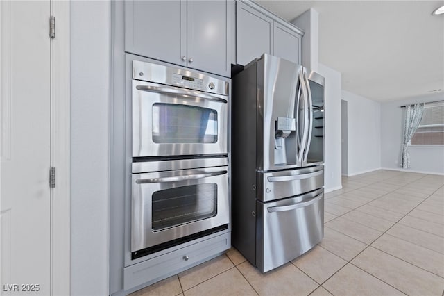 kitchen featuring light tile patterned flooring, gray cabinets, and stainless steel appliances