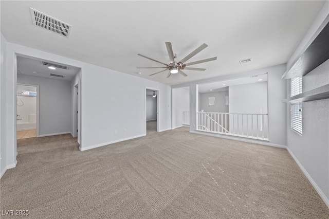 carpeted empty room featuring visible vents, baseboards, and a ceiling fan