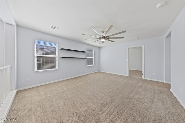 spare room with light carpet, baseboards, visible vents, and ceiling fan