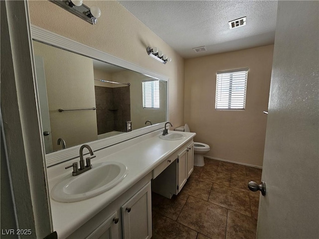 full bathroom featuring toilet, double vanity, a sink, and visible vents