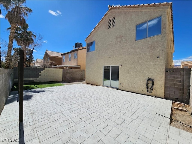 back of property with a patio, a fenced backyard, a tiled roof, and stucco siding