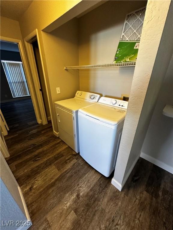 laundry room featuring baseboards, laundry area, dark wood-type flooring, and washer and dryer