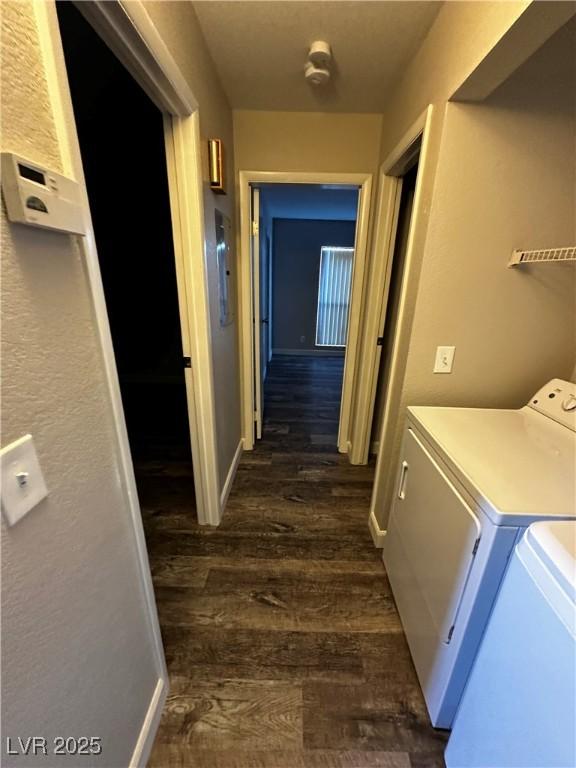 hallway with independent washer and dryer, dark wood finished floors, and baseboards