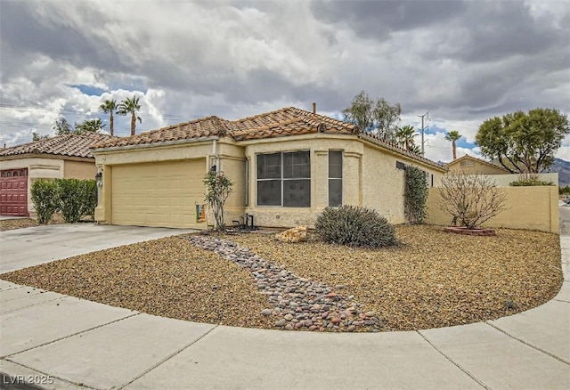 mediterranean / spanish-style house with a tile roof, driveway, an attached garage, and stucco siding