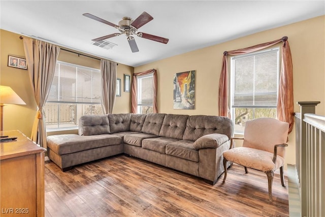 living room featuring ceiling fan, visible vents, and wood finished floors