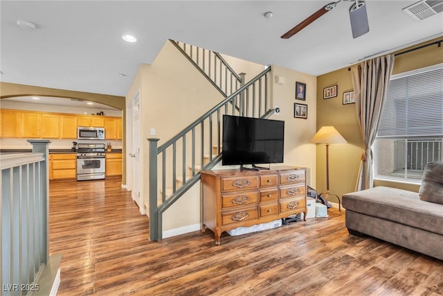 living area featuring recessed lighting, visible vents, a ceiling fan, light wood-type flooring, and stairs