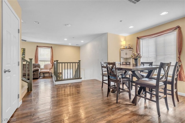 dining space with baseboards, wood finished floors, visible vents, and recessed lighting