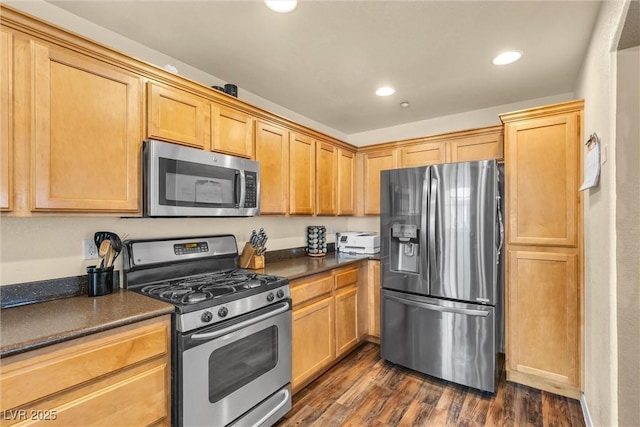 kitchen with dark wood-style floors, appliances with stainless steel finishes, dark countertops, and recessed lighting