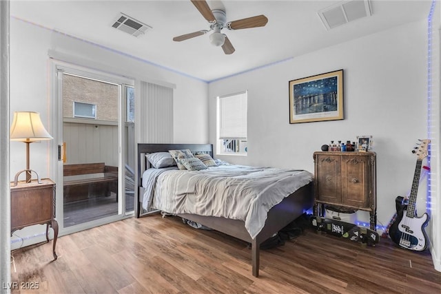 bedroom with ceiling fan, visible vents, and wood finished floors