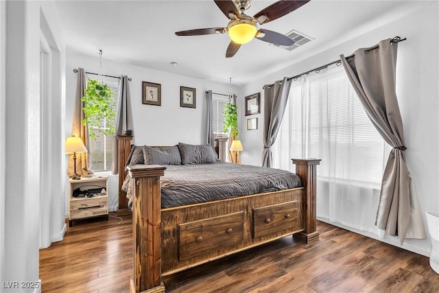 bedroom with ceiling fan, visible vents, and wood finished floors