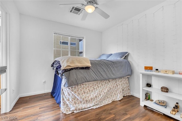 bedroom featuring a ceiling fan, visible vents, baseboards, and wood finished floors