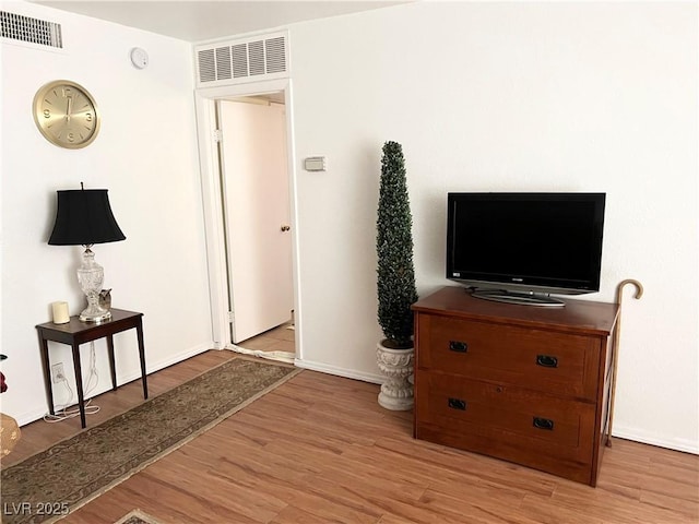 interior space featuring wood finished floors, visible vents, and baseboards