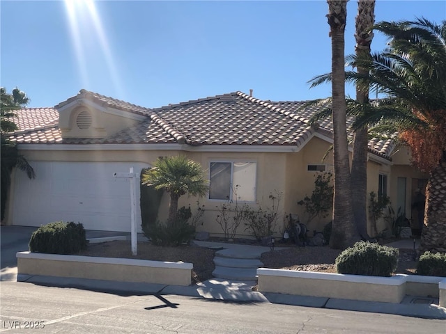 mediterranean / spanish-style home featuring concrete driveway, a tiled roof, a garage, and stucco siding