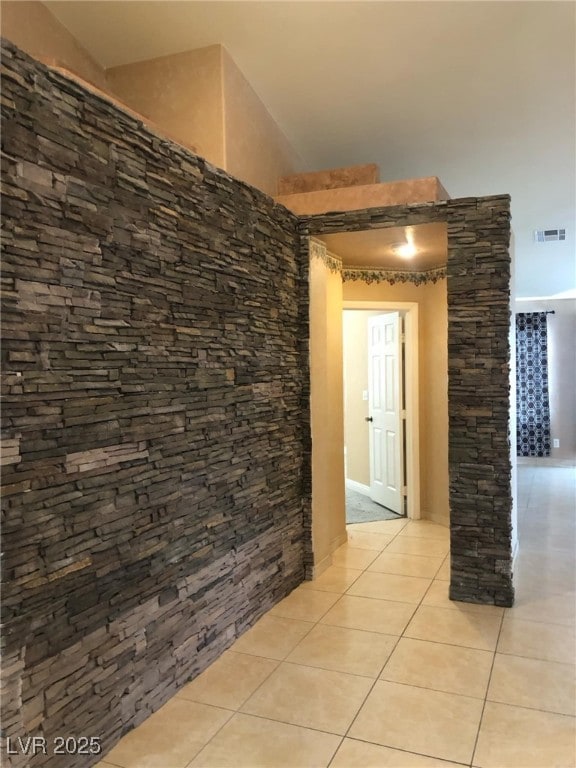 hallway featuring light tile patterned floors and visible vents