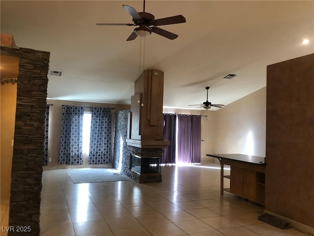 unfurnished living room featuring ceiling fan, visible vents, a multi sided fireplace, and light tile patterned flooring