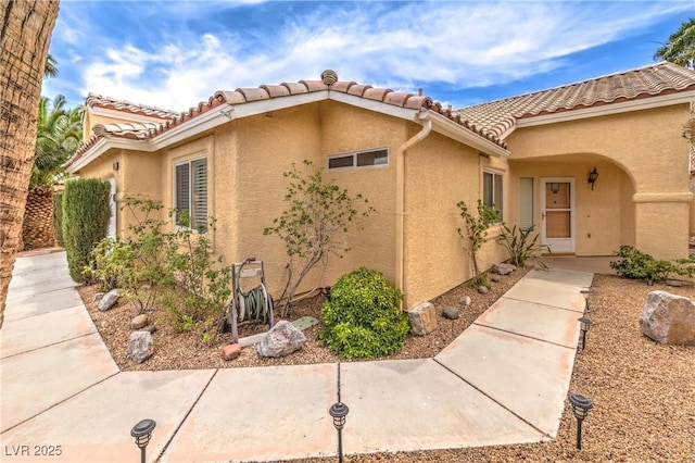 7613 Falconwing Ave, Las Vegas, NV 89131 - view of side of home with stucco siding and a tile roof
