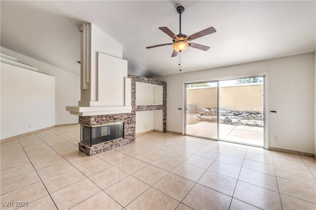 7613 Falconwing Ave, Las Vegas, NV 89131 - unfurnished living room with ceiling fan, light tile patterned flooring, vaulted ceiling, a stone fireplace, and baseboards