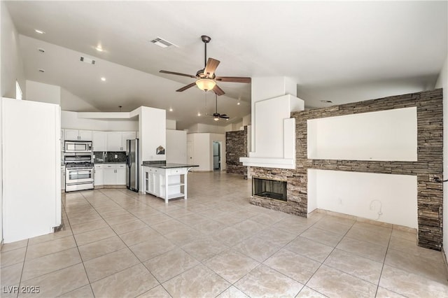 7613 Falconwing Ave, Las Vegas, NV 89131 - kitchen featuring appliances with stainless steel finishes, open floor plan, a ceiling fan, dark countertops, and light tile patterned floors