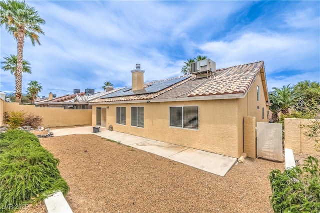 7613 Falconwing Ave, Las Vegas, NV 89131 - back of property featuring stucco siding, solar panels, a fenced backyard, a patio area, and a tiled roof
