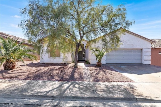 view of front of home with driveway, an attached garage, and stucco siding