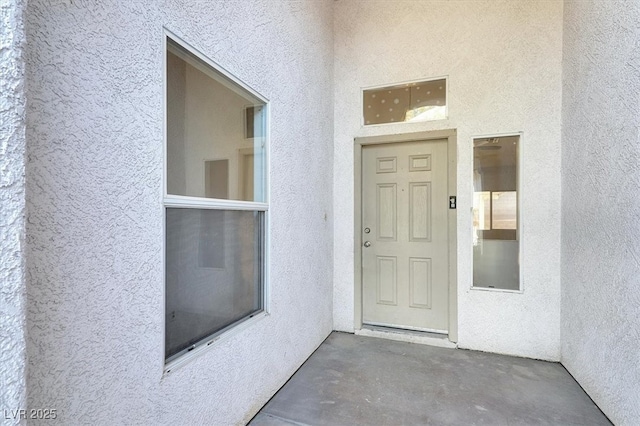 entrance to property featuring stucco siding