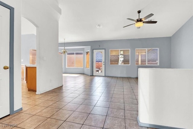 spare room with arched walkways, visible vents, ceiling fan, and light tile patterned floors