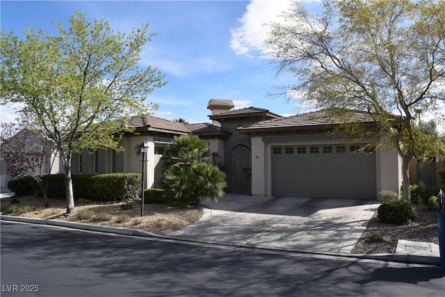 view of front facade with stucco siding, an attached garage, and driveway