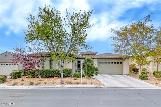 view of front facade with concrete driveway, an attached garage, and stucco siding