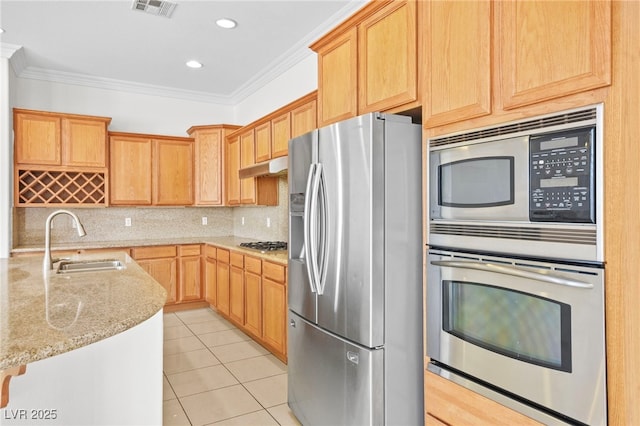 kitchen with light tile patterned flooring, a sink, ornamental molding, stainless steel appliances, and under cabinet range hood