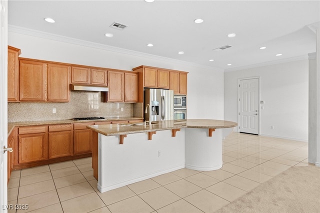 kitchen with under cabinet range hood, visible vents, appliances with stainless steel finishes, and a sink