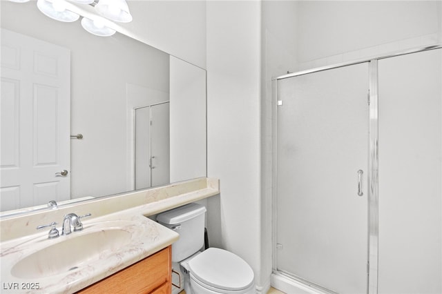 bathroom featuring a shower stall, vanity, and toilet