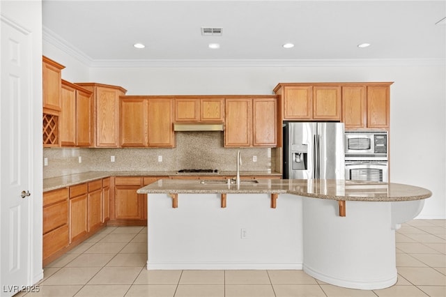 kitchen featuring a sink, light tile patterned flooring, under cabinet range hood, and stainless steel appliances