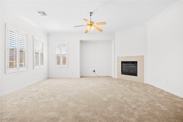 unfurnished living room with visible vents, carpet floors, ceiling fan, ornamental molding, and a tile fireplace