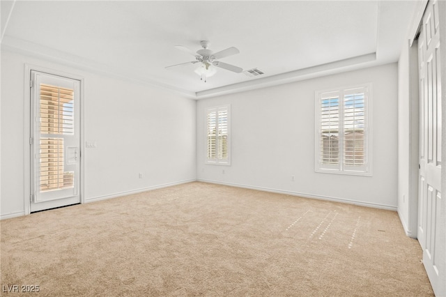 unfurnished bedroom featuring visible vents, light colored carpet, baseboards, and multiple windows