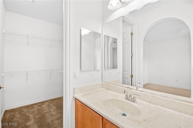 bathroom with vanity and a spacious closet