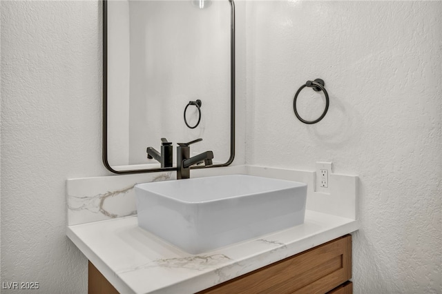 bathroom featuring vanity and a textured wall