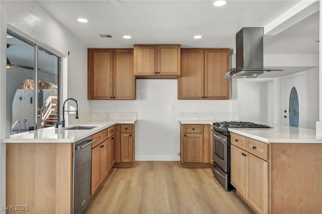 kitchen featuring ventilation hood, visible vents, a peninsula, a sink, and appliances with stainless steel finishes