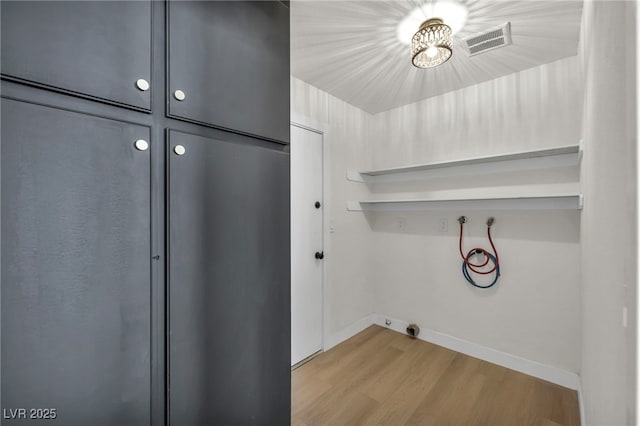 washroom with hookup for a washing machine, wood finished floors, visible vents, baseboards, and laundry area