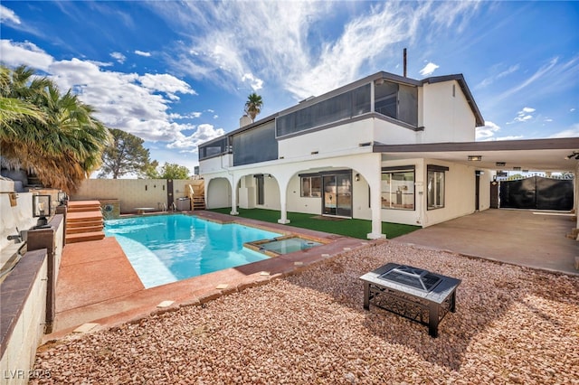 back of property featuring stucco siding, a fenced backyard, a fire pit, a sunroom, and a patio area