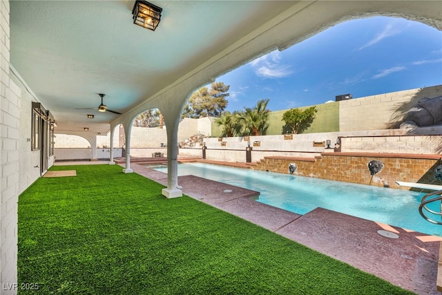 view of swimming pool with a ceiling fan, a fenced in pool, a yard, a fenced backyard, and a patio area