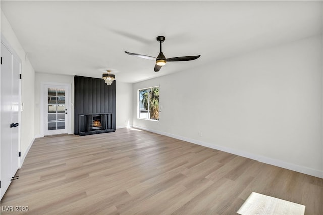 unfurnished living room featuring baseboards, light wood-style floors, ceiling fan, and a fireplace