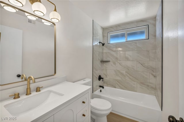 full bathroom featuring vanity, wood finished floors, visible vents, shower / bathing tub combination, and toilet