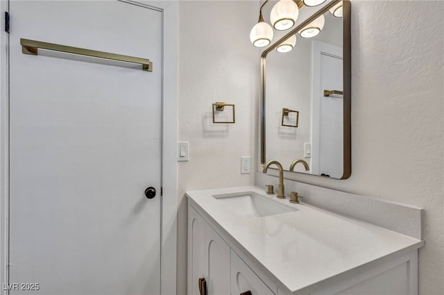 bathroom featuring vanity and a textured wall