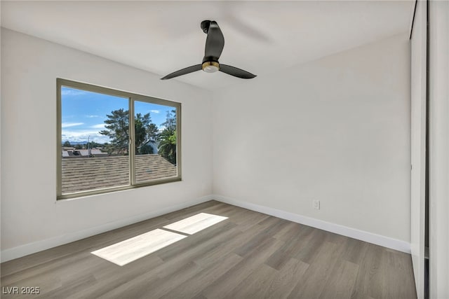 unfurnished room with ceiling fan, baseboards, and wood finished floors