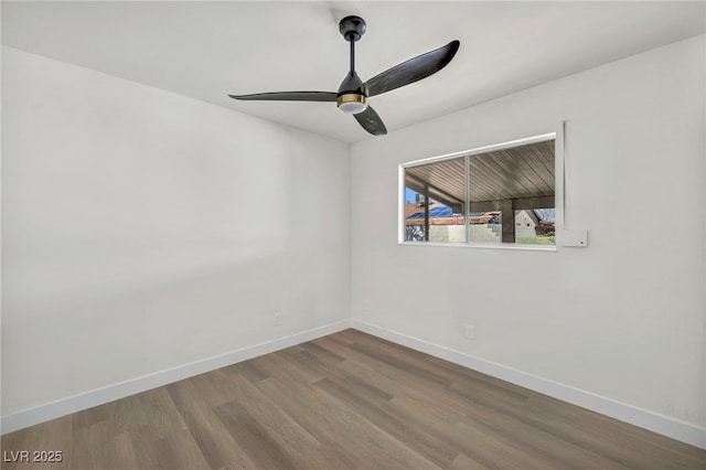 spare room featuring ceiling fan, baseboards, and wood finished floors