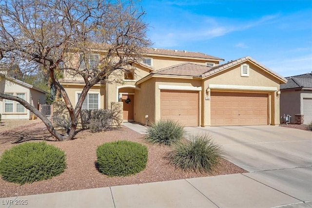 view of front of home with stucco siding, concrete driveway, an attached garage, and a tiled roof