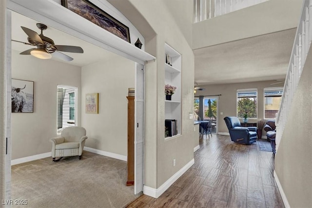 corridor with plenty of natural light, baseboards, and built in shelves