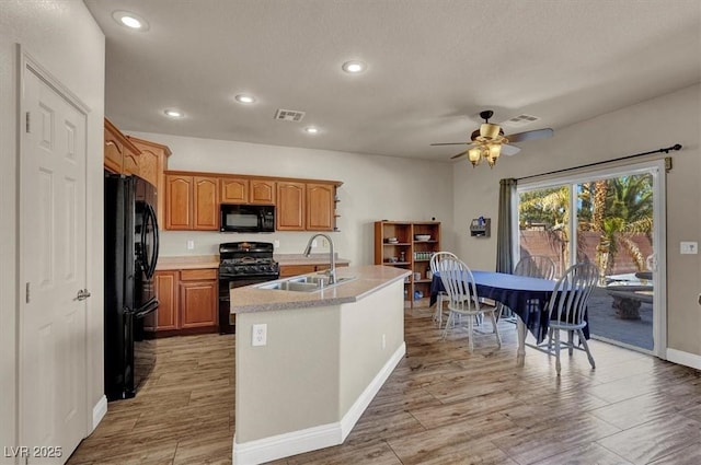 kitchen with visible vents, light countertops, recessed lighting, black appliances, and a sink